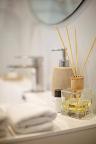 a glass vase with bamboo sticks in it on a counter at Cloud 9 Boutique Hotel and Spa in Cape Town
