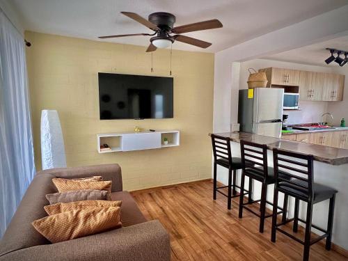 a living room with a couch and a kitchen with a bar at Departamento Maderas in Tuxtla Gutiérrez