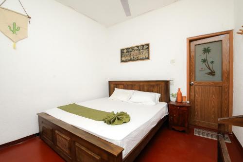 1 dormitorio con 1 cama con sábanas blancas y puerta en Surf Dine, en Matara