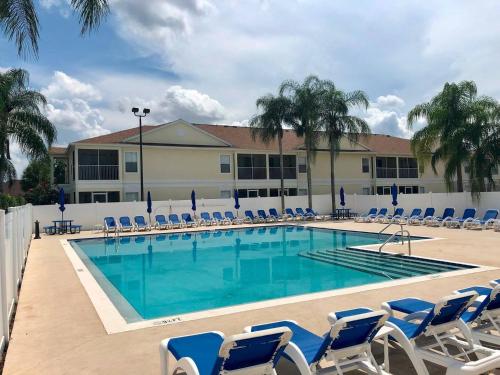 a large swimming pool with chairs and a building at Grand Holiday 3BR Palms Condo near Disney Parks in Kissimmee