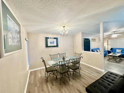 a dining room and living room with a table and chairs at Grand Holiday 3BR Palms Condo near Disney Parks in Kissimmee