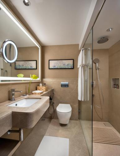a bathroom with a sink and a toilet and a mirror at Ekante Bliss Tirupati - IHCL SeleQtions in Tirupati