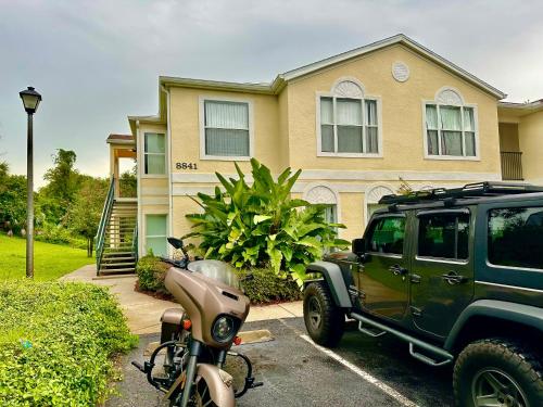 a motorcycle parked in a parking lot in front of a house at Grand Holiday 3BR Palms Condo near Disney Parks in Kissimmee