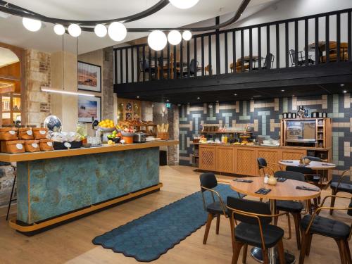 a restaurant with tables and chairs and a counter at Hotel Maison Louise Lille Centre - Handwritten Collection in Lille