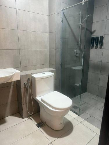 a bathroom with a toilet and a glass shower at K Avenue by Rilekbah in Donggongon