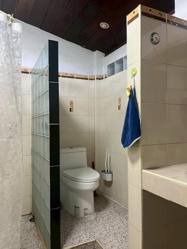 a small bathroom with a toilet and a shower at Uncle Matts Cafe and Chill in Chiang Mai