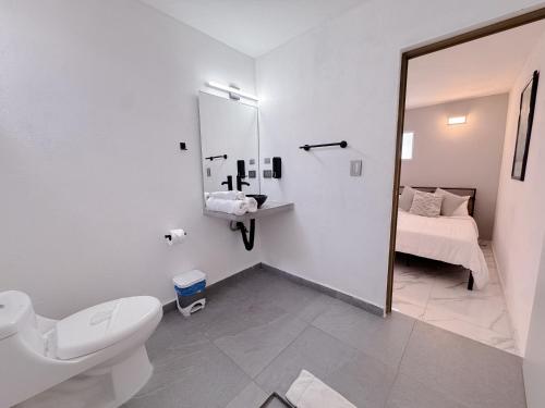 カンクンにあるDowntown Suites - Hotel Boutique by Marafのトイレ、洗面台、鏡のあるバスルーム