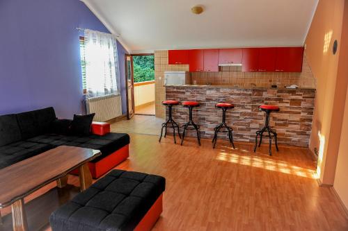 uma sala de estar com um sofá e uma cozinha em Apartman Selena em Trebinje