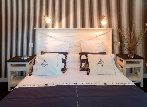 a bedroom with a large bed with white sheets and pillows at Hotel Les Embruns in Le Touquet-Paris-Plage