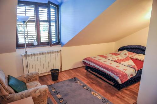 um quarto com uma cama, uma cadeira e uma janela em Apartman Selena em Trebinje