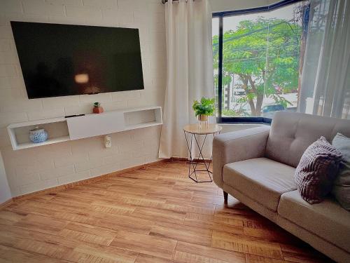 a living room with a couch and a flat screen tv at Departamento Nubes in Tuxtla Gutiérrez