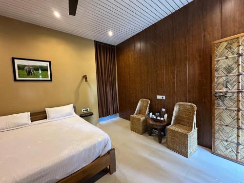a bedroom with a bed and a table and chairs at Kaziranga Tea Nest Homestay in Kāziranga