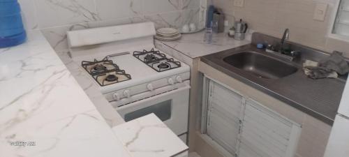 eine Küche mit Herd und Spüle in der Unterkunft Jeremi Apartamentos in Colorado