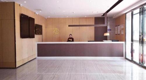 a man standing behind a counter in a kitchen at IU Hotels·Hefei Lujiang Andeli Plaza in Lujiang