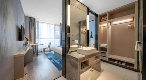 a bathroom with a sink and a large mirror at Echarm Hotel Jinan West Station International Exhibition Center in Jinan