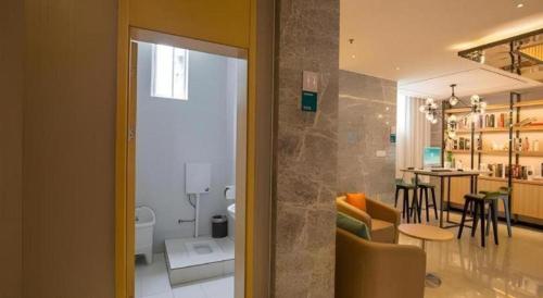 a room with a living room and a dining room at City Comfort Inn Deyang Shifang Yonghu Park in Shifang