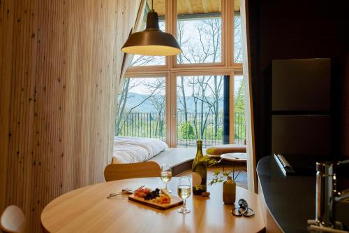 a room with a table and a large window at SANU 2nd Home 軽井沢1st in Oiwake