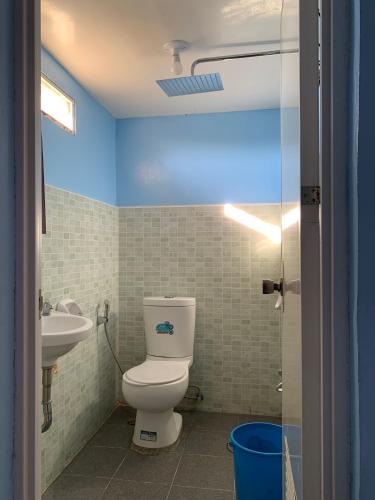 a bathroom with a toilet and a sink at Old Parola Seaside Inn in Baler