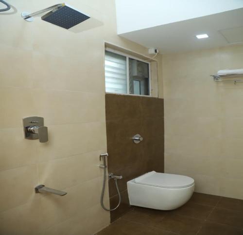 ein Bad mit einem WC und einer Dusche mit einem Fenster in der Unterkunft SK Home Stay in Mayiladuthurai