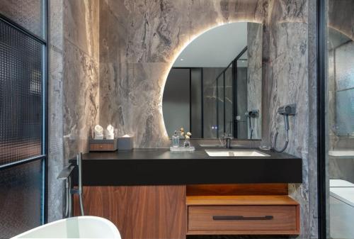 um banheiro com uma pia e um espelho em Floral Hotel em Datong