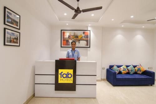 a man standing at a podium in a room at FabHotel La Serene BnB- Ashok Vihar in New Delhi