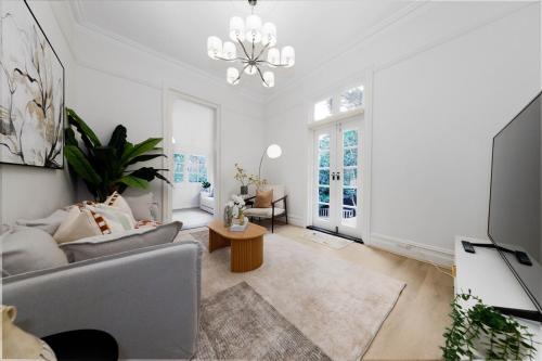 a living room with a couch and a chandelier at Spacious 3BR Family Home at Central Chatswood in Sydney