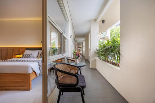 a bedroom with a bed and a table with a chair at Bali True Living in Denpasar