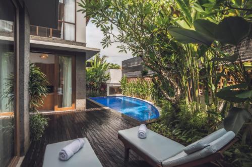 ein Hinterhof mit einem Swimmingpool und einem Haus in der Unterkunft Teratai Villa Canggu by Ini Vie Hospitality in Canggu