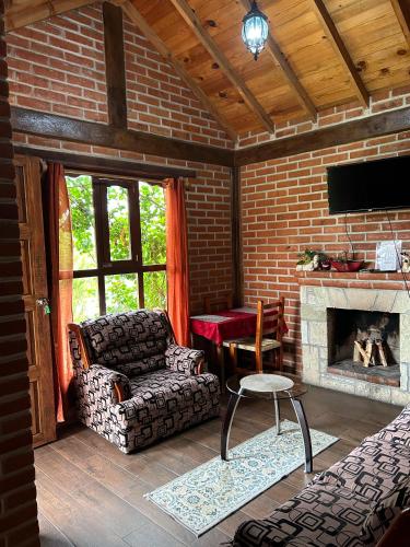 a living room with a couch and a fireplace at Cabañas villa de San Miguel in Huasca de Ocampo