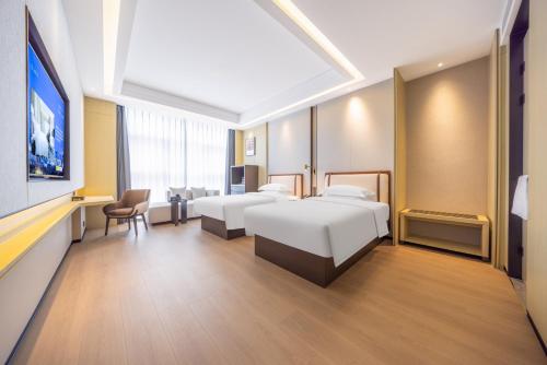 Postel nebo postele na pokoji v ubytování 云颐自在酒店鄂尔多斯东胜区全民健身中心店