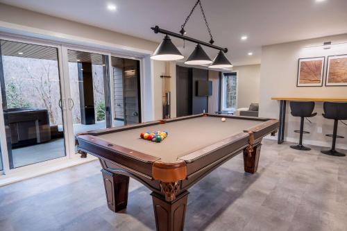 a pool table in a living room with at Ski in - Ski out - SPA & Pool Table - Le Konect in Saint-Philémon