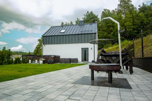 a stone patio with a building in the background at KASZUBY - Domki na Szczycie - jeden na ogrodzonej działce z balia jacuzzi na wyłączność in Krzeszna