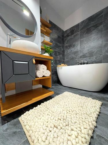 a bathroom with a bath tub and a rug and a bath tub at ParkView in Craiova