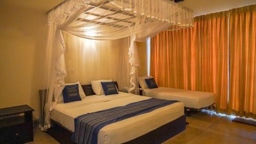 TikaliCINEC Eco Resort的一间卧室配有两张带天蓬的床