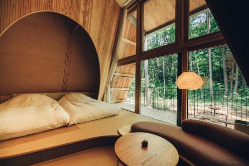 a bed in a room with a large window at SANU 2nd Home 河口湖1st in Fujikawaguchiko