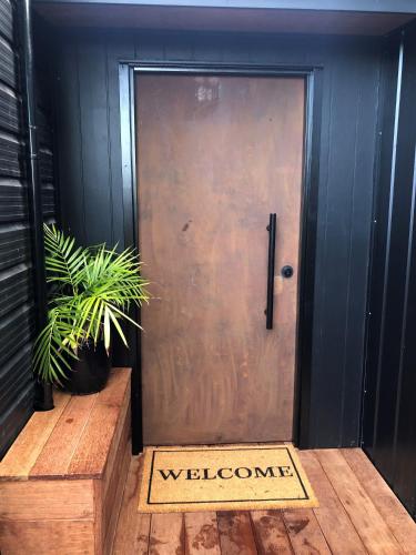 a door with a welcome sign in front of it at Hamurana Roost in Rotorua