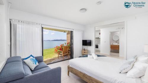 una camera da letto con un letto grande e una grande finestra di Lanimer ONE - Beautiful Waterfront Property a Soldiers Point