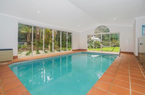 a swimming pool in a house with windows at Hideaway with us, on Tamborine Mountain in Mount Tamborine