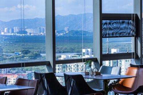 um restaurante com mesas e cadeiras em frente às janelas em Atour S Hotel Shenzhen Futian Port em Shenzhen