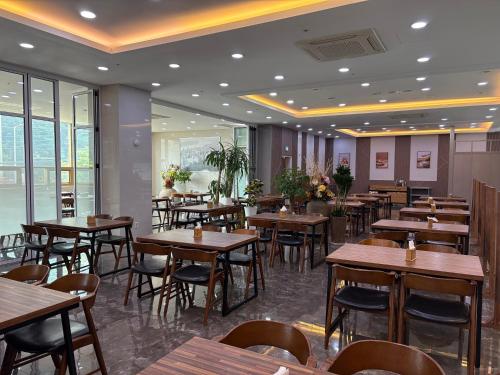 Gimpoにあるホテル ラル 金浦の木製のテーブルと椅子と窓のあるレストラン