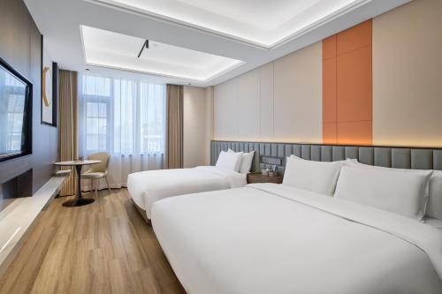 een hotelkamer met twee bedden en een televisie bij Xi'an Yunzhi Hotel in Xi'an