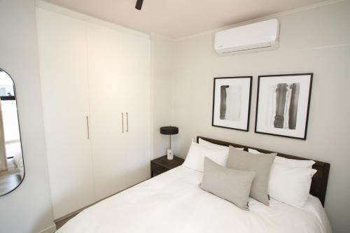 克尼斯纳303 Seahorse - Premium 2 Bedroom Apt with Pool & Parking的卧室里有一张床，床单和枕头都是白色的