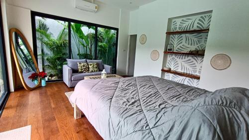 a bedroom with a large bed and a couch at Sarang Jati Mansion in Ban Saiyuan (1)