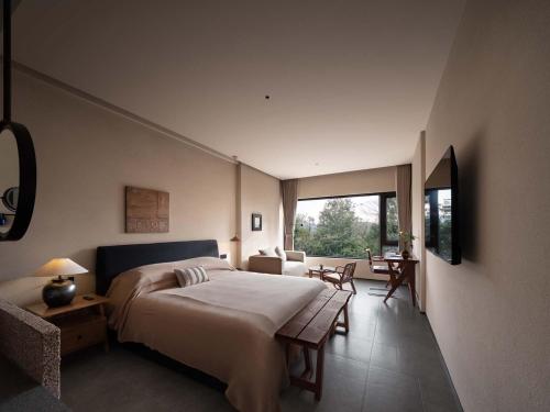 a bedroom with a large bed and a living room at Shanyu Art Garden Homestay in Fuzhou