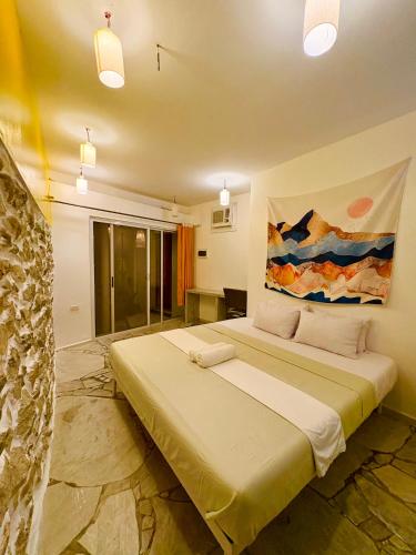ein Schlafzimmer mit einem großen Bett und einem Gemälde an der Wand in der Unterkunft Lonos Circle Terrace view in Romblon