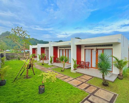 a house with a green yard with palm trees at Talvista Kintamani Villa in Kintamani