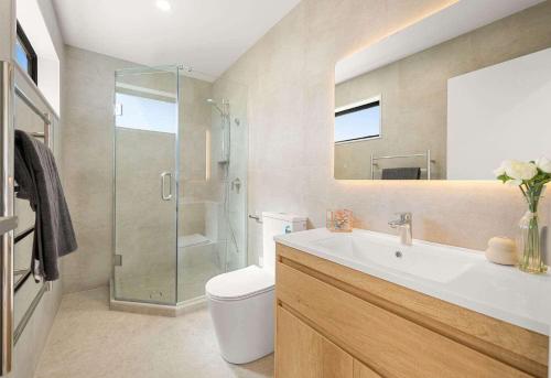 a bathroom with a toilet and a sink and a shower at Duo Duo in Auckland