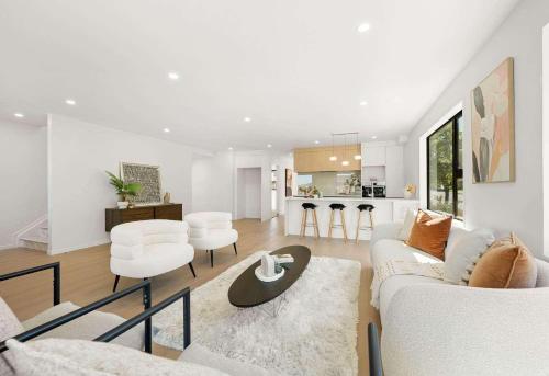 a white living room with a white couch and chairs at Duo Duo in Auckland
