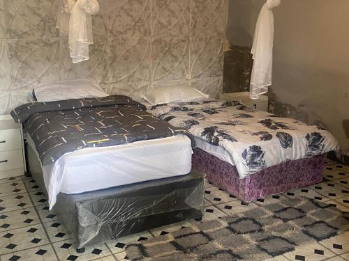 two twin beds in a room with a mirror at Aeropark Residencial(1) in Maputo