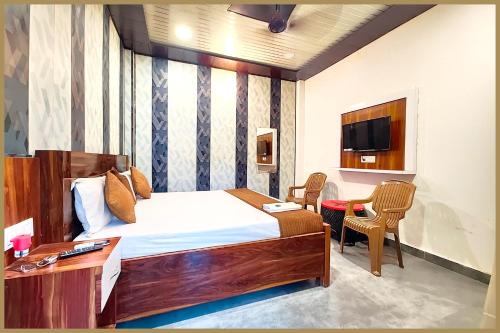 sypialnia z łóżkiem, biurkiem i telewizorem w obiekcie Tarunpura Road Giridhari The Rama- Krishna Palace Near Ram-Janam-Bhoomi # Railway Station - Free Wifi and Parking Available - Fully Air Conditioning Rooms - Best Premium Hotel In Ayodhya w mieście Ayodhya